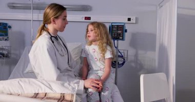 Şefkatli bir doktor, muayene sırasında genç bir hastayla sıcak ve dikkatli bir şekilde iletişim kurar.