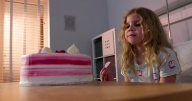 Genç bir kız nefis ve canlı bir pastanın tadını çıkarıyor. Lezzetli bir tatlının tadını çıkarıyor.