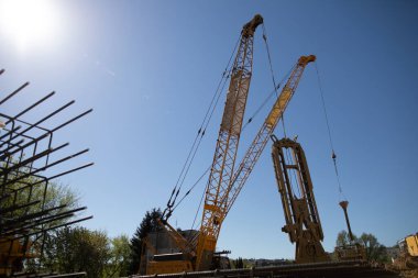 Vinçler ve ağır ekipmanlar önemli endüstriyel faaliyetlere sahip hareketli bir inşaat sahasında çalışıyor