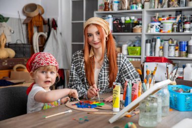 Sevgi dolu bir anne ile çocuğunun sanat ve zanaat faaliyetleri arasında paylaşılan neşeli bir an.