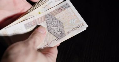 Çeşitli banknotları tutan ellerin kapanması, döviz kurunun dinamiklerini ve mali işlemleri gözler önüne seriyor