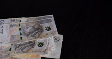 Çeşitli para birimleri notlarını gösteren detaylı bir yakın plan görüntüsü zıt bir koyu arkaplanda titizlikle düzenlenmiştir