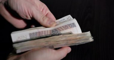 Para sayan ellerin yakın plan görüntüsü, para birimlerini içeren mali işlemleri gösteriyor.