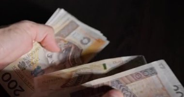Düşük ışıklandırma koşulları altında çeşitli banknotları ustalıkla saymanın ayrıntılı bir yakın görüntüsü