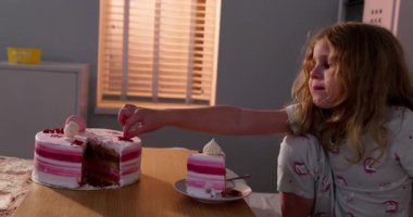 Genç bir çocuk, sıcak bir hastane ortamında lezzetli ve lezzetli bir pastayla mutlu bir şekilde şımarır.