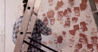 Yetenekli bir birey, yenilikçi teknikleri ve sanatsal yeteneklerini sergileyerek merdivene duvar boyar.