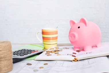 Pembe kumbaralı rahat bir sahne, dumanı tüten bir kahve fincanı ve bütçe ve finansal planlama araçları.