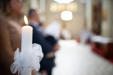 Huzurlu bir tören ortamında titreyen bir mum, bir kutlama anını ve saygıyı vurguluyor..