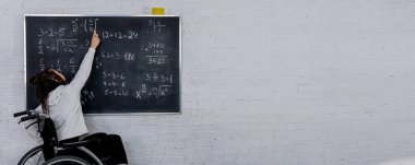 Tekerlekli sandalyedeki ilham verici bir öğretmen, öğrencileri temel matematik kavramlarını karatahtaya sunarak yakınlaştırır.