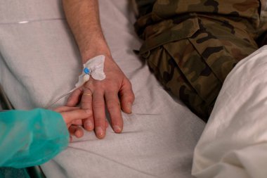 Bir hastanede iç içe geçmiş iki elin dokunaklı sahnesi derin aşkı ve sarsılmaz desteği simgeliyor.