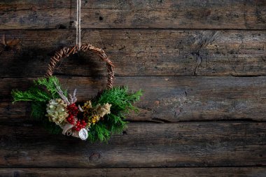 Şaşırtıcı derecede güzel asılı bir çiçek çelengi engebeli bir ahşap zemine nazikçe sergileniyor.