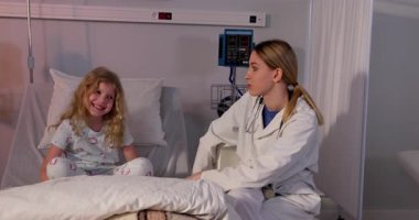 Bir hastane odasında, şefkatli bir hemşire ve genç bir kız özen ve sıcaklıkla dolu dokunaklı bir anı paylaşıyorlar.
