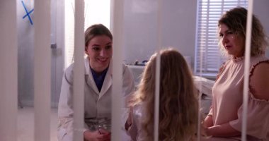 Bilge bir doktor, tıbbi bir ortamda genç bir kız ve annesiyle samimi ve şefkatli bir şekilde iletişim kurar.