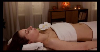 Güzel bir kaplıcada, masaj masasında uzanan bir kadınla huzurlu ve huzurlu bir rahatlama anı.