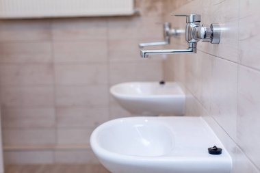 Moda ve çağdaş banyo lavabolarını krom musluklarla donatılmış minimalist bir mekanda deneyin.
