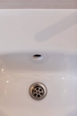 Zarif ve minimalist beyaz bir lavabo. Zarafet için modern paslanmaz çelik drenaj tasarımı içeriyor.