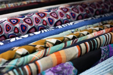 Moda tasarımı için eşsiz desenler sergileyen canlı ve renkli çeşitli kumaşlar.