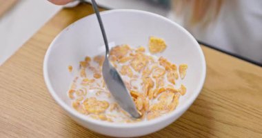 Gerçekten tatmin edici bir kase mısır gevreği, besleyici ve enerjik bir kahvaltı için taze sütle ustalıkla karıştırılıyor.