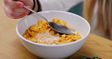 Bir insan lezzetli mısır gevreğine neşeyle kremalı süt ekler ki bu kahvaltı için mükemmeldir.