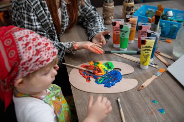 Bu hoş bir sanat aktivitesidir. Bir çocuk neşe içinde neşeli renkler keşfeder. İlgili bir bakıcının yanında.