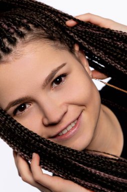 Bu güzel bir yakın plan portresi, gülümseyen genç bir kadın, şaşırtıcı saç stilini sergiliyor.