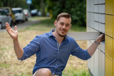 Şık bir genç adam rahat ve şık bir yaz görüntüsü sergileyerek güvenli bir şekilde dışarıda poz veriyor.