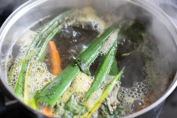 Taze otlar ve canlı sebzelerle zenginleştirilmiş lezzetli bir çorba tenceresi lezzetli bir mutfak tabanı oluşturuyor.