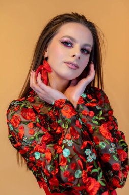 Göz kamaştırıcı bir manken zarif bir şekilde güzel çiçekler ve çarpıcı bir makyajı sergiliyor.