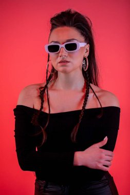 Şık bir model, modaya uygun güneş gözlükleriyle, izleyicileri büyüleyen çağdaş bir estetik sergiliyor.