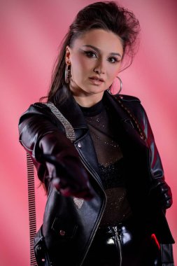 Bir model kendine güvenerek cesur moda sergiliyor. Göz alıcı derisi ve modaya uygun pembe ışıklı örgüler.