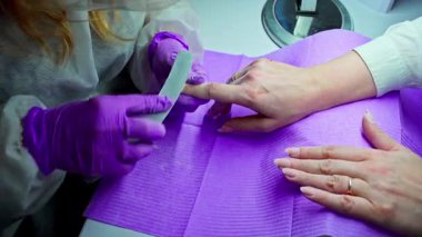 Profesyonel bir manikür, hassas aletler ve güzellik için gelişmiş teknikler kullanarak yetenekli tırnak bakımını gösterir.