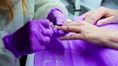 Bu, çeşitli tırnak boyama teknikleri ve kullanılan araçları gösteren bir manikür oturumunun yakın görüntüsü