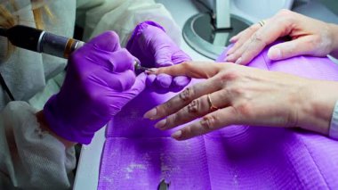 Uzman bir tırnak teknisyeni gelişmiş aletler ve özel tekniklerle olağanüstü bir manikür yapıyor.