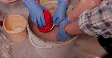 Sanatçılar çeşitli nesneleri rengarenk bir karışıma daldırırlar, yaratıcılıklarını ve sanatlarını sergilerler.