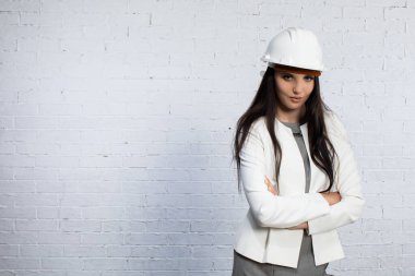 Sert şapka takan güçlü, kendine güvenen bir kadın modern bir çalışma ortamında profesyonellik ve kararlılık sergiliyor.