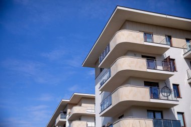 Bu şık apartman kompleksi, canlı mavi gökyüzüne karşı modern mimariyi gözler önüne seren balkonları barındırıyor.