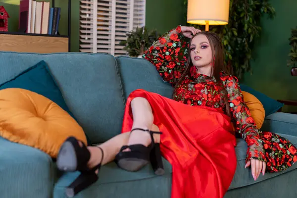 Şık bir model koltukta zarif bir şekilde uzanır, moda tercihlerini ve canlı renkleri her yerde sergiler.