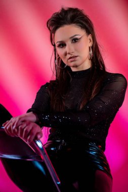 Moda kıyafetli bir modelin büyüleyici bir portresi. Parlak, canlı ışıklandırma efektleriyle geliştirilmiş.