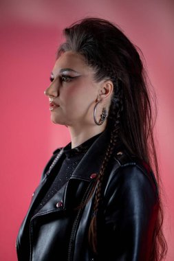 Çarpıcı bir profil çekimi. Gergin moda, canlı ve renkli arkaplan dekoruyla birlikte sergileniyor.