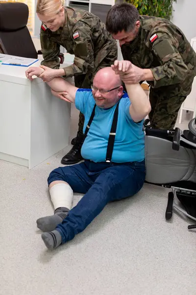 Zor durumdaki bir bireye yardım eden, takım çalışması ve bakım sergileyen acil durum ekiplerini gösteren bir sahne..