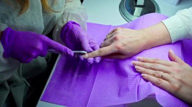 Yetenekli bir tırnak teknisyeni, müşteriler için harika sonuçlar elde etmek için modern aletlerle gelişmiş manikür hizmetleri sunuyor.