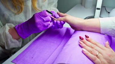 Yetenekli bir sanatçı şık bir salonda canlı oje sürerek müşteri memnuniyetini ve zarafetini sağlar.