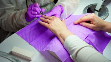 Çarpıcı bir yakın çekim titiz bir manikür sürecini yakalıyor, hem tırnak sanatını hem de profesyonelliğini gösteriyor.