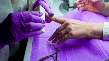 Yetenekli bir tırnak teknisyeni, çarpıcı güzellikteki tırnaklar için özel aletler kullanarak detaylı bir manikür yapar.