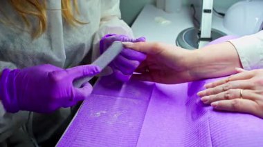 Yetenekli bir tırnak teknisyeni sağlıklı tırnaklara ve görsel estetiğe odaklanarak detaylı bir manikür yapar.