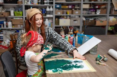 Neşeli bir sanat oturumunda, bir çocuk canlı boya kullanarak yaratıcılıklarını keşfetmek için bir yetişkine katılır.