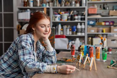 Yetenekli genç bir sanatçı sanat malzemeleri ve boyalarla dolu canlı bir stüdyoda yaratıcı sürecin tadını çıkarıyor.