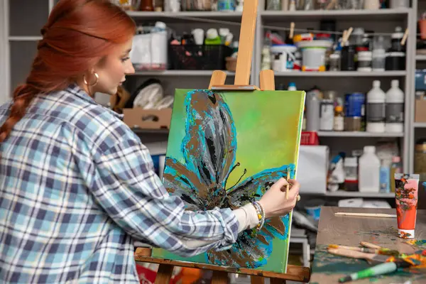 Yetenekli bir sanatçı tuval üzerinde canlı bir çiçek çizer, hayal gücünün geliştiği bir stüdyoda yaratıcılık sergiler.