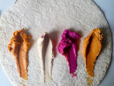 Düz ekmekte sunulan renkli ve canlı yiyecekler herhangi bir sosyal toplantıda görsel olarak çekici bir aperatif oluşturur.