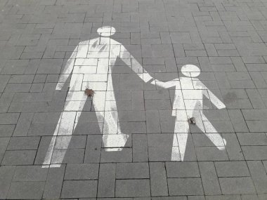 Çok güzel boyanmış bir sembol. Bir ebeveyni temsil ediyor. Bir çocuğu nazikçe kucağında tutuyor.